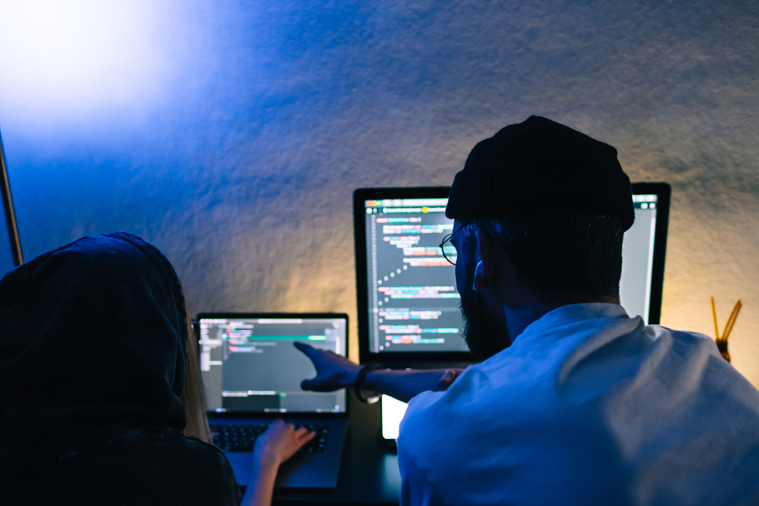 Mobile developers team writes program code on a computer, programmers work in home office.